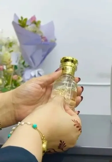 Arabic perfume label being applied to a bottle